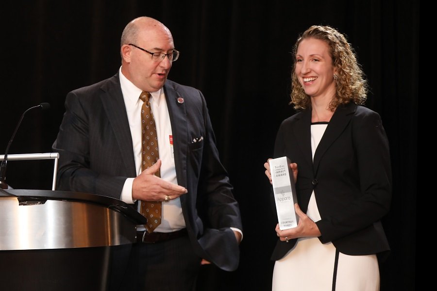 Courtney Ramey accepting TechExec Community Impact Award from Apparo Board Chair Mike Keating